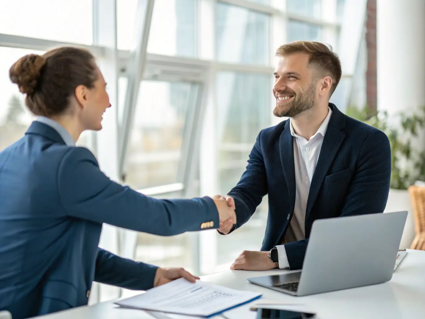 A manager shaking hands with a new international employee, symbolizing the successful placement and integration of talent into the company.